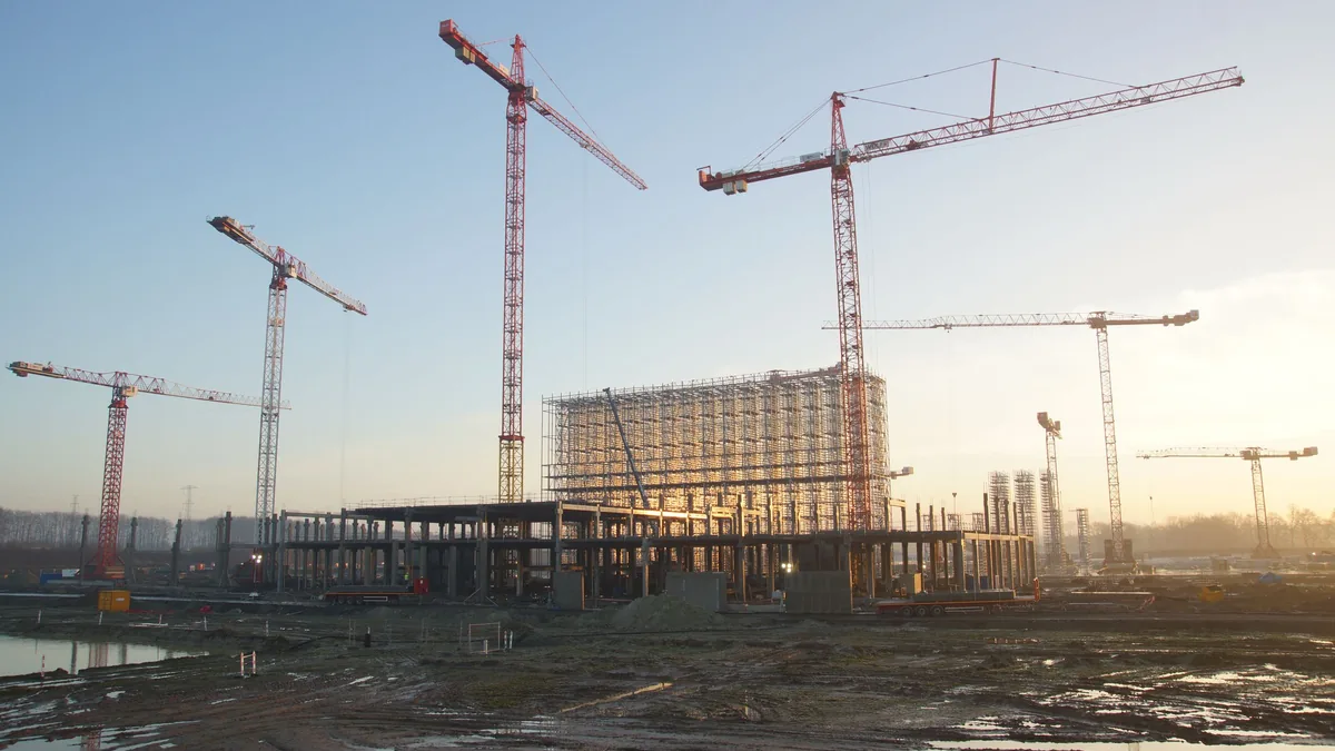 夕陽下的建築工地與吊車，說明建商經營風險