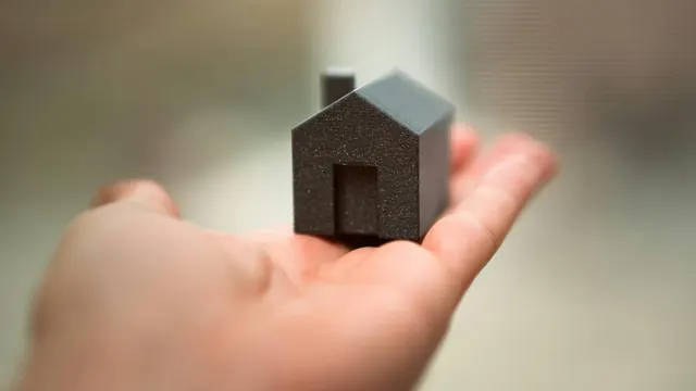 手持住宅模型，說明持分不動產貸款評估重點